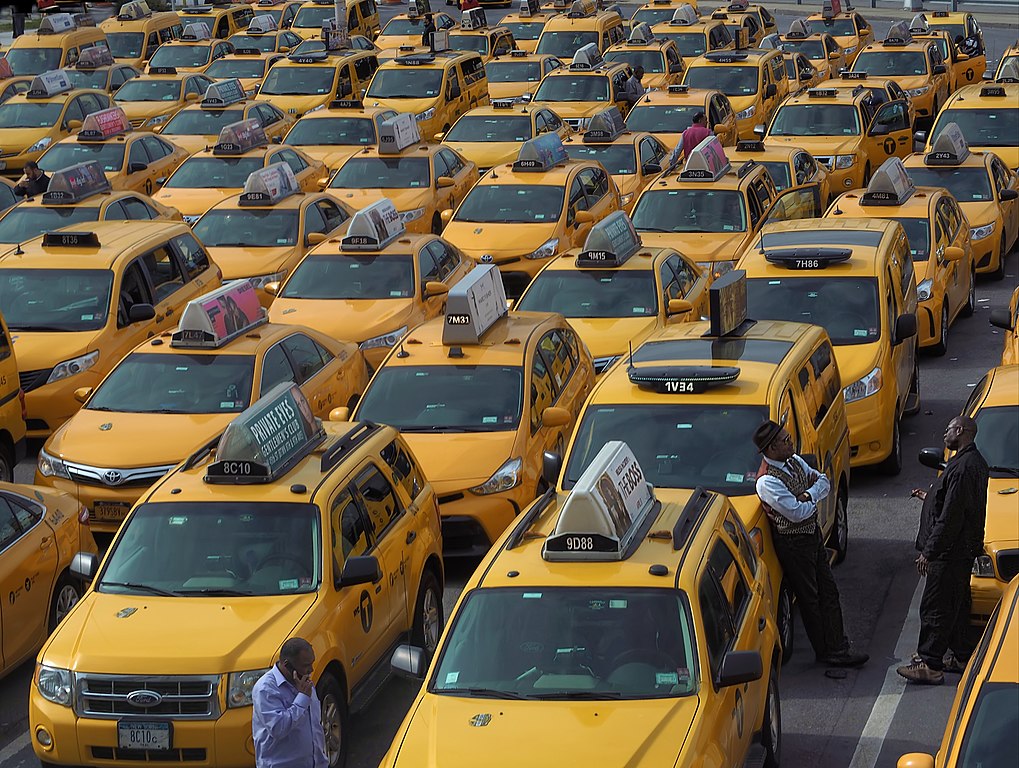 Image of taxis waiting in several long lines.